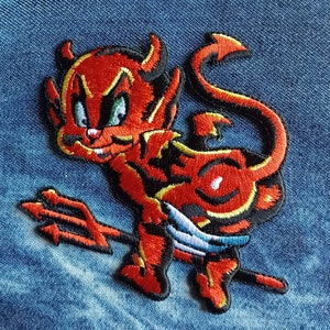May include: Red and black embroidered iron-on patch of a cartoon devil holding a trident.