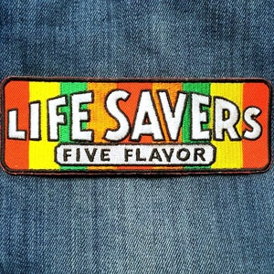 May include: A red, orange, yellow, green, and blue embroidered patch with the text "LIFE SAVERS FIVE FLAVOR" on a denim background.