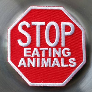 May include: Red stop sign with white text that reads "STOP EATING ANIMALS".
