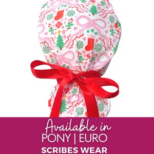 May include: A white scrub cap with a festive Christmas pattern featuring pink bows, green Christmas trees, red stockings, and candy canes. The cap is tied with a bright red satin ribbon. The text "SCRIBES WEAR" is visible.