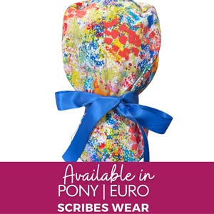 May include: A colourful scrub cap with a vibrant abstract paint-splatter design in red, yellow, blue, and green. The cap is tied with a bright blue satin ribbon. The text "Available in PONY | EURO SCRIBES WEAR" is displayed on a pink banner.