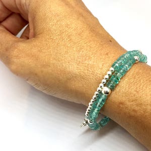 May include: A double-strand bracelet with teal blue gemstone beads and silver spacer beads.