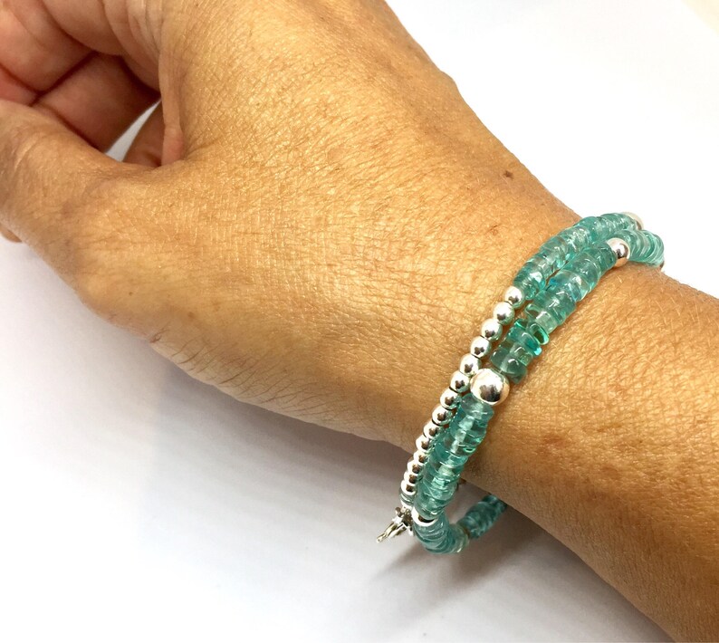 May include: A double-strand bracelet with teal blue gemstone beads and silver spacer beads.