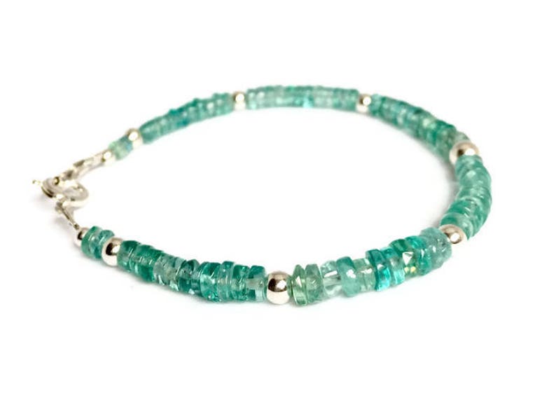May include: A green gemstone bracelet with silver beads and a silver clasp.