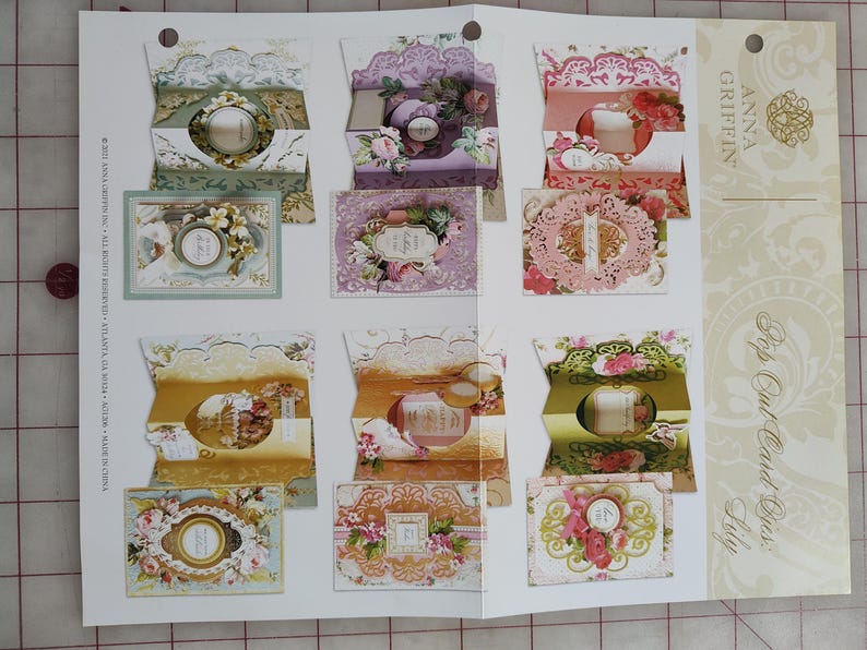 May include: A set of three ceramic mugs with a speckled, matte finish. The mugs are in shades of cream, light gray, and dark gray. Each mug has a simple, minimalist design and a rounded handle.