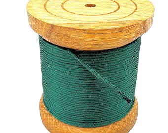 May include: A wooden spool of dark green thread. The spool is made of light-colored wood with a circular top and bottom. The thread is tightly wound around the central core of the spool. The spool is approximately 2 inches tall.
