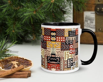 May include: White ceramic mug with a black rim and handle. The mug features a colorful geometric pattern inspired by African tribal art.