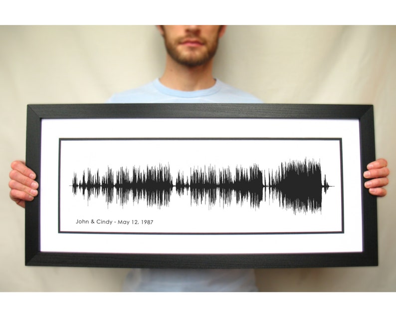May include: A black framed print of a sound wave with the text "John & Cindy - May 12, 1987" below the wave.