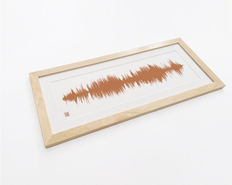 May include: A framed print of a sound wave in a light brown color. The frame is made of natural wood and has a white mat.
