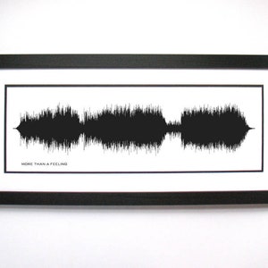 May include: A black and white framed print of a sound wave with the text "MORE THAN A FEELING" below it.
