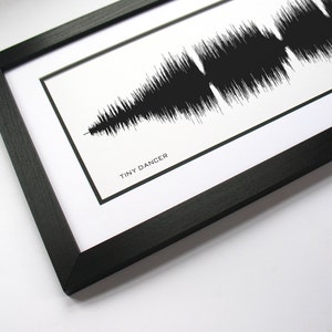 May include: A black framed print with a black and white sound wave graphic and the text "TINY DANCER" below the graphic.