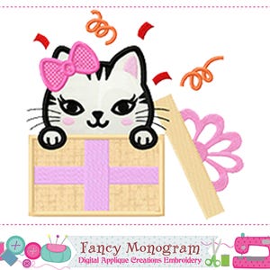 May include: An embroidery design featuring a white cat with black stripes and a pink bow, peeking out of a tan gift box with a light purple ribbon. The scene includes orange curly streamers and red confetti pieces, with a pink flower shape nearby.