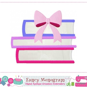 Puede incluir: Diseño bordado que representa una pila de tres libros con detalles en rosa, morado y azul, coronada por un gran lazo rosa. El diseño incluye el texto "Fancy Monogram Digital Applique Creations Embroidery".