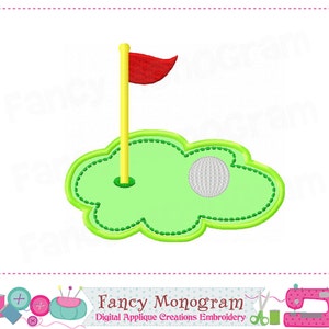 以下が含まれることがあります： 緑のゴルフコースにゴルフボールと黄色のポールに赤い旗が立っています