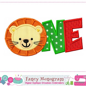 May include: Embroidered design of a lion with the word "ONE" in green and red letters with white stars. The design is perfect for a first birthday party.
