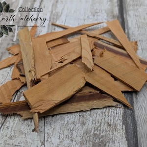 May include: A pile of light brown wood chips with a rough texture. The chips vary in size and shape, with some appearing as long, thin strips. The image includes the text "Earth alchemy Collection".