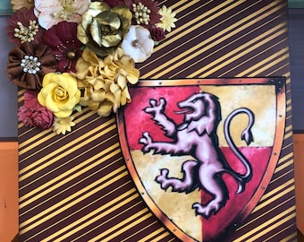 May include: A brown and gold striped background with a red, yellow, and gold lion crest. The crest is surrounded by a gold frame with decorative accents. The background is decorated with a cluster of red, yellow, and gold paper flowers.