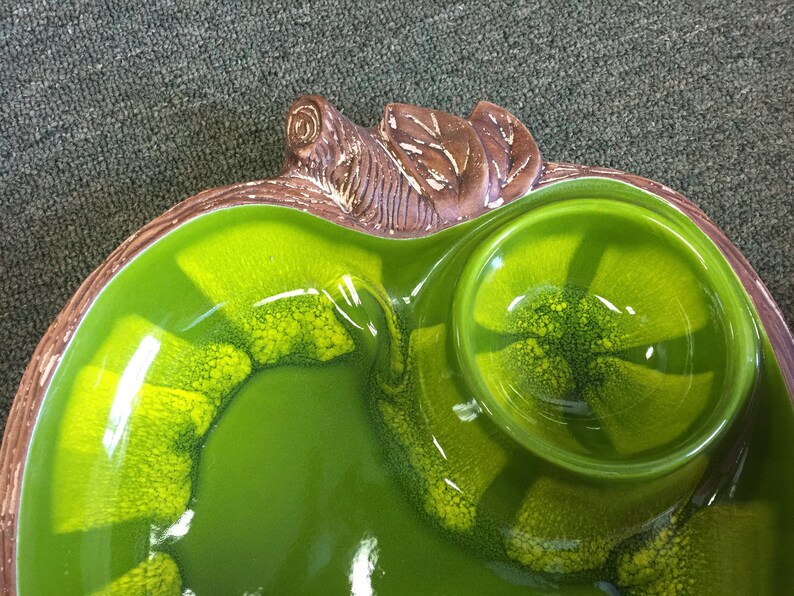 Puede incluir: Un plato de servir de cer&aacute;mica verde con un dise&ntilde;o de tortuga marr&oacute;n. El plato tiene un cuenco grande y poco profundo y un cuenco peque&ntilde;o y redondo.