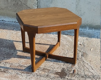 May include: A brown wooden end table with a hexagonal top and a unique X-shaped base.