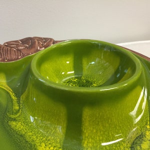 Puede incluir: Un plato de servir de cer&aacute;mica verde con un cuenco elevado en el centro. El plato tiene un esmalte verde y amarillo moteado.
