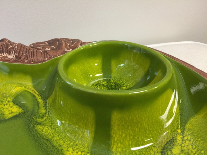 Puede incluir: Un plato de servir de cer&aacute;mica verde con un cuenco elevado en el centro. El plato tiene un esmalte verde y amarillo moteado.