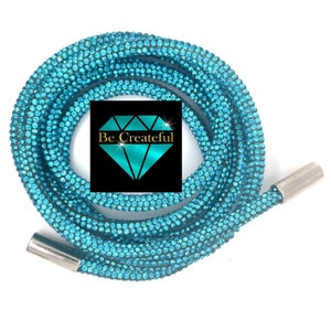 May include: A turquoise blue rhinestone chain with silver end caps. The chain is coiled and the text "Be Createful" is visible in the center of the image.