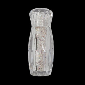 May include: A clear glass bottle with a faceted design filled with iridescent glitter.