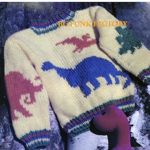 May include: A yellow knitted jumper with a dinosaur design. The jumper has a blue dinosaur, a red dinosaur, a green tree, and a pink dinosaur. The jumper has a multi-coloured stripe around the bottom and the neck. The text "BC FUNK FACTORY" is visible on the jumper.