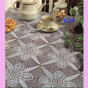 May include: White crocheted tablecloth with a square pattern and a delicate floral design. The tablecloth is set with a teapot, teacups, cookies, and a jar of candy.
