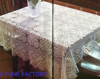 May include: A rectangular off-white crochet tablecloth featuring an intricate repeating geometric and floral pattern with a scalloped edge. The textile is draped over a table, displaying a detailed openwork design throughout the fabric.