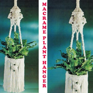 Könnte beinhalten: Ein weißer Makramee-Pflanzenaufhänger mit gewebtem Design, der eine grüne Pflanze hält. Der Aufhänger hat einen Fransenboden und dekorative Perlen. Der Text "MACRAME PLANT HANGER" ist rot gedruckt.