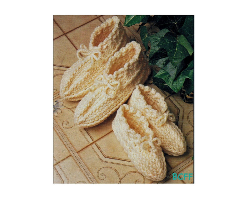 May include: Three pairs of crocheted slippers in a cream colour. The slippers have a ruffled edge and a tied bow at the top.