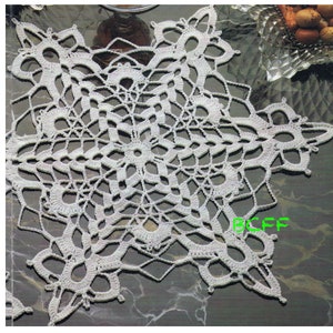 以下が含まれることがあります： 繊細で複雑なデザインの白いクロシェットのドイリー。ドイリーは細い糸でできており、円形です。