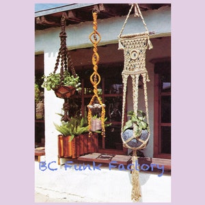 Könnte beinhalten: Drei Makramee-Pflanzenhänger mit unterschiedlichen Designs und Farben, die an einem Fensterrahmen hängen. Die Hänger sind aus Naturfaserseil gefertigt und weisen eine Vielzahl von Knoten und Mustern auf. Die Hänger sind mit Quasten und Perlen verziert. Die Hänger halten Pflanzen in Töpfen.