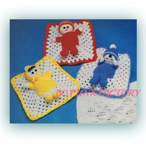 May include: Three crocheted baby dolls, each with a different coloured outfit, are lying on crocheted blankets. The dolls are wearing red, blue, and yellow outfits. The blankets are white with a crocheted border.