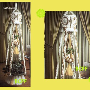 May include: A white macrame plant hanger with a brown and white patterned design. The hanger has a round top and a tassel at the bottom. The hanger is hanging from a white curtain.