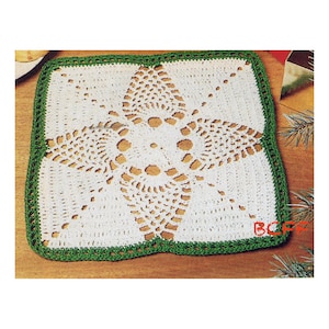 May include: White crochet doily with a green border and a starburst design in the center.