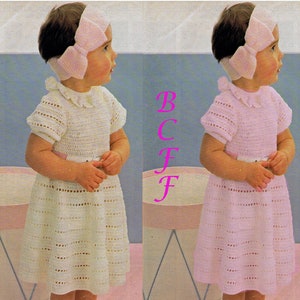 Könnte beinhalten: Vintage-Bild eines kleinen Kindes in einem gehäkelten Kleid mit passendem Stirnband. Das Kleid ist weiß mit einem Bubikragen und kurzen Ärmeln. Eine hellrosa Schleife ziert das Stirnband. Das Kleid hat einen Gürtel in der Taille.