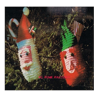 May include: Two crocheted Christmas stocking ornaments, one with a Santa face and the other with a green elf hat and a pink face. Both are hanging on a green tree branch.