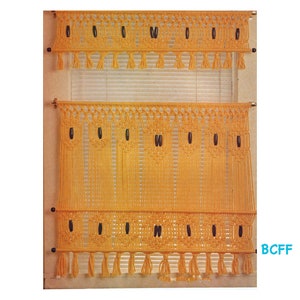 May include: A set of two yellow macrame window valances with black beads and fringe. The valances are hung on a window with white blinds.