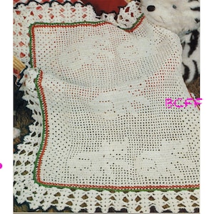 May include: A white crocheted baby blanket with a green, red, and black border. The blanket is made with a simple stitch pattern and has a scalloped edge.