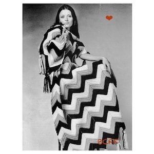 Może przedstawiać: Czarno-biały chevronowy koc z frędzlami. Koc jest zarzucony na krzesło, a kobieta siedzi na krześle.
