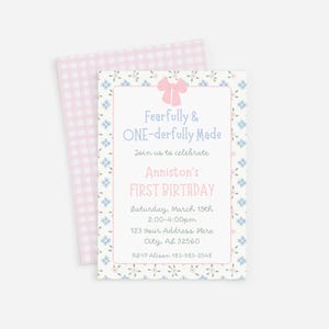 May include: A floral-themed invitation for a first birthday celebration. The invitation features a pink bow, blue floral accents, and the text "Fearfully & ONE-derfully Made." The invitation includes the name "Anniston," date, time, and address.