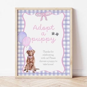 Puede incluir: Un letrero enmarcado con las palabras "Adopta un cachorro" en escritura rosa. Se presenta una ilustración a la acuarela de un perro marrón con un gorro de fiesta y una pajarita. El fondo es un patrón de cuadros azul y blanco.