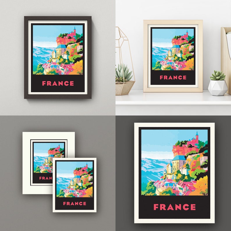 May include: A colorful illustration of a French village with the word "FRANCE" printed in pink letters. The village is situated on a cliff overlooking a valley. The illustration is framed in black.