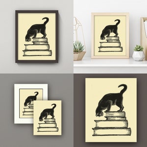 May include: Black cat art print. The artwork depicts a black cat standing atop a stack of books. The cat is in a curious pose, with its head lowered. The print has a vintage aesthetic, with a cream-colored background and a dark brown frame.
