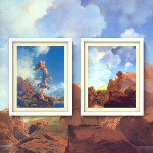 May include: Two framed landscape paintings with a white frame. The painting on the left features a woman in a white dress standing on a rocky cliff with a blue sky and clouds in the background. The painting on the right features a person sitting on a rocky cliff with a blue sky and clouds in the background.