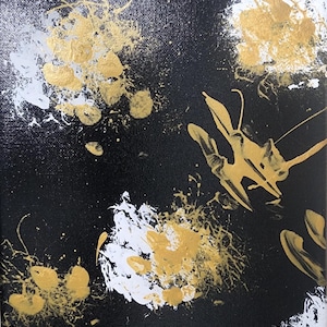 May include: Abstract art painting on canvas. The artwork features splatters and brushstrokes in gold, white, and silver against a black background. The composition is dynamic and textured, with a modern aesthetic.