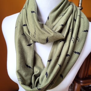 May include: A green infinity scarf with a black lightning bolt pattern.