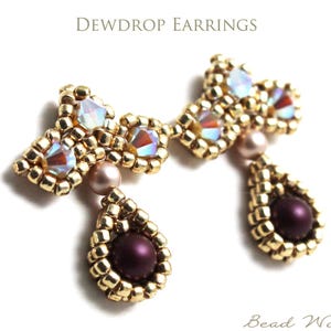 May include: Dewdrop Earrings. A pair of beaded earrings featuring gold-colored seed beads, iridescent faceted crystals, and dark purple round beads. The design includes a teardrop-shaped dangle suspended from a beaded frame. Text reads Dewdrop Earrings.
